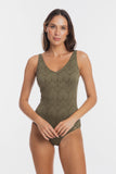 A woman modeling a sleeveless one-piece swimsuit with a textured chevron pattern in olive green, set against a plain light gray background.