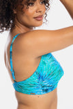 A woman wearing a blue and turquoise abstract-patterned bikini top, shown from a side-back angle against a clean white background.