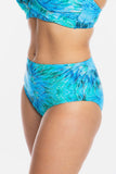 A close-up of a model wearing a two-piece bikini with a vibrant blue and green abstract wave pattern, set against a plain white background.