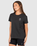 Woman wearing a black t-shirt with a logo on a light gray background