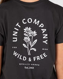 Black t-shirt with white floral design and text on a person wearing it. Unit Ladies Tees - Blush - Washed Black
