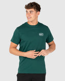 Man wearing a green t-shirt with a logo on a light gray background Unit Mens Tees - Index - Forest Green