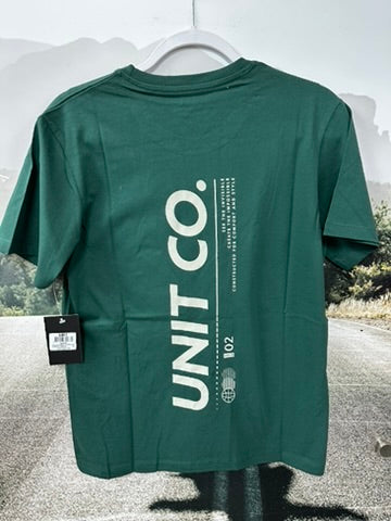 Green t-shirt with 'UNIT CO.' branding on a hanger against a blurred outdoor background.