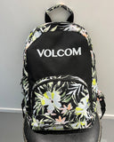 A Volcom backpack with a black base, featuring a white floral print on the sides, front pocket, and top trim, with the brand name 'VOLCOM' printed in white on the front black panel.