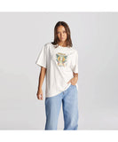 A female model wearing a white slouchy t-shirt with a graphic in the center, paired with blue jeans.