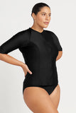 Woman wearing a black swimsuit with long sleeves on a white background