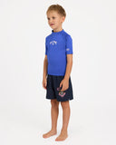 Billabong Boys Groms All Day Arch Rashguard in Cobalt blue side profile view showing the comfortable regular sleeve length extension and clean anti chafe underarm panel architecture alignment, sold by Point Break Cambridge local family surf shop at 63 Duke street.