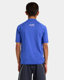 Billabong Boys All Day Arch UPF 50 Rashguard in Cobalt blue back view showing the smooth solid panel alignment relaxed athletic swim fit silhouette and clean flatlock perimeter hemline stitching, sold by Point Break Cambridge local family surf shop at 63 Duke street.