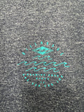 Gray t-shirt with teal graphic design on a textured fabric background