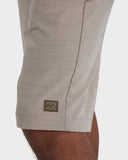 Billabong Mens Crossfire Hybrid Walkshorts in Khaki sand close up view highlighting the premium quick dry water repellent woven fabric texture custom branded button and heavy duty pocket seam stitching details, sold by Point Break Cambridge local family surf shop at 63 Duke street.