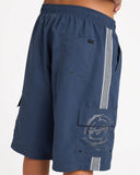 Billabong Mens Throw On 3.0 22 inch Boardshorts in Dusty Indigo blue side profile view highlighting the extra-long 22 outseam hemline rise and comfortable relaxed leg opening architecture, sold by Point Break Cambridge local family surf shop at 63 Duke street.