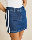 A blue denim mini skirt with two vertical white stripes down the side, shown on a model wearing a white top against a light beige background.