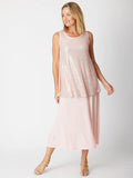 Woman wearing a light pink sleeveless top and skirt set on a white background
