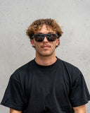 Dragon Vinyl Sunglasses in Matte Black front view showing the bold lifestyle frame layout and premium glare-reducing LUMALENS Smoke Polarized lenses, sold by Point Break Cambridge local family surf shop at 63 Duke street.
