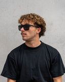 Dragon Vinyl Sunglasses in Matte Black side profile view highlighting the comfortable slight wrap curvature secure temple arm taper and iconic stamped brand logo details, sold by Point Break Cambridge local family surf shop at 63 Duke street.