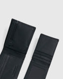 Black leather bifold wallet shown open, displaying interior compartments, card slots, and a zipper pocket, photographed on a light gray background.