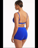 A woman shown from the back wearing a bright royal blue two-piece swimsuit with a bra-style top and high-waisted shorts, photographed against a clean white studio background. sea-level-essentials-twist-front-dde-cup-bra-cobalt-back
