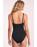 A woman shown from the back wearing a black one-piece swimsuit with adjustable shoulder straps, against a plain light background. Back view of the Sea Level Essentials Spliced One Piece Swimsuit in Black, showing the back coverage and adjustable shoulder straps.