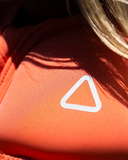 Follow Corp Womens Life Vest in Melon pink close up view highlighting the premium soft touch super stretch neoprene fabric weave texture heavy duty locking zipper pull and refined lining detailing, sold by Point Break Cambridge local family surf shop at 63 Duke street.