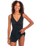 Front view of the TOGS black swim dress twist one piece swimsuit showing the flattering A-line skirt overlay with the model lifting the skirt p to show what's underneath.