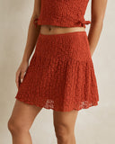 Model wearing the Rhythm Gigi Lace Mini Skirt - Red on a plain background