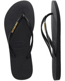 Havaianas Slim Logo Metallic Jandals in Black and Gold front view showing the elegant open toe thong configuration and delicate slim black straps with raised metallic gold logo print, sold by Point Break Cambridge local family surf shop at 63 Duke street.