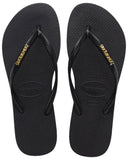 Havaianas Slim Logo Metallic Jandals in Black and Gold front view showing the elegant open toe thong configuration and delicate slim black straps with raised metallic gold logo print, sold by Point Break Cambridge local family surf shop at 63 Duke street.