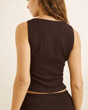 A woman shown from the back wearing a dark brown ribbed sleeveless crop top and matching bottoms against a plain light beige background. Rhythm Indie High Neck Tank - Chocolate