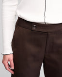Brown pants with a white shirt on a gray background