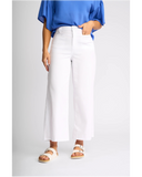 Front view of the Knewe Label Index Jean in White Denim, showcasing the clean cut and flattering waistband layout. White wide-leg cropped pants worn by a model, styled with a blue blouse and beige double-strap sandals against a light gray studio background.