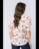Close-up detail of the delicate soft textile matrix and feminine Latte Bloom light floral print design. Back View