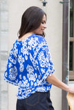 Back view of model wearing the ladies Leila + Luca Movement Blouse displaying the flowing silhouette and clean hemline.