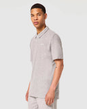 Oakley Relax Urban Polo Shirt in New Granite Heather grey side profile view showing the comfortable sleeve length and split side hem details, sold by Point Break Cambridge local family surf shop at 63 Duke street.