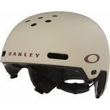 Side profile view of the Matte Sand Oakley ST1 helmet displaying the cooling ventilation channels and adjustable chin strap.