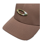 Oakley Tincan Cap in Dark Umber brown close up view highlighting the textured metal icon and moisture wicking internal sweatband, sold by Point Break Cambridge local family surf shop at 63 Duke street.