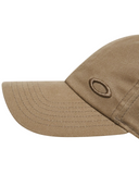 Oakley Tinfoil 3.0 LX Cap in Pebble tan close up view highlighting the premium textured fabric panels raised metal badge anchorage and internal performance sweatband tape detailing, sold by Point Break Cambridge local family surf shop at 63 Duke street.