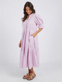 Woman wearing a light purple dress with puffed sleeves on a white background