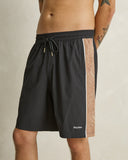 Model wearing the Rhythm Panel Stretch Beach Short - Black on a plain background