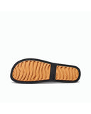 Close-up detail of the water-friendly textured footbed and durable TPU straps on the black and tan Reef sandals.