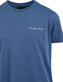 Blue t-shirt with 'ST. GOLIATH' logo on a white background. Close up detail of the premium navy cotton jersey fabric weave, ribbed neckline stitching, and Saint Goliath internal branding.