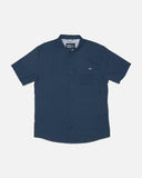 Salty Crew Mens Flagship UV Button Up in Mid Blue marine tone front view showing the lightweight short sleeve sun shirt silhouette tailored collar placket closures and dual chest utility button pockets, sold by Point Break Cambridge local family surf shop at 63 Duke street.