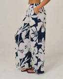 Salty Crew Womens Graphic Bloom Pant in Dark Navy blue side profile view showcasing the sleek side seam construction flexible leg openings and comfortable relaxed upper hip fit, sold by Point Break Cambridge local family surf shop at 63 Duke street.