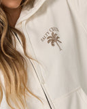 Salty Crew Womens Pretty Palm Hooded Zip in Off White cream close up view highlighting the premium soft cotton weave vintage washed fleece texture full-zip teeth borders and stitched brand clamp label, sold by Point Break Cambridge local family surf shop at 63 Duke street.