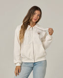 Salty Crew Womens Pretty Palm Hooded Zip in Off White cream front view showing the comfortable relaxed zip-up fleece silhouette full-length metal zipper protective attached hood lines and clean graphic chest print, sold by Point Break Cambridge local family surf shop at 63 Duke street.