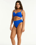 Woman wearing a blue bikini on a white background Side profile angle of the Cobalt Sea Level Essentials Cross Front Underwire Bikini Top, highlighting the supportive side boning.