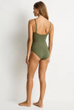 Woman wearing a green swimsuit against a white background Back view of the Sea Level Essentials Cross Multifit One Piece Swimsuit in Khaki, showing the classic back coverage and adjustable straps.