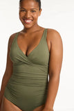 Plus Sized Woman wearing a green swimsuit on a white background Detailed close-up macro view of the premium recycled eco fabric texture and cross-front stitching on the Khaki Sea Level swimsuit.