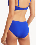 A model shown from the back wearing a bright royal blue two-piece bikini with a bandeau-style top and high-waisted bottoms against a plain white background. Back view of the Sea Level Essentials Mid Bikini Pant in Cobalt, displaying the smooth fabric finish and classic mid-coverage rear.