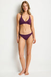 Woman wearing a purple bikini set on a white background