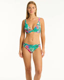 A female model wearing a Sea Level bikini with a floral design in green and other colors. Front view of the Sea Level Pacifico Regular Cheeky Pant in Evergreen showing the mid-rise waist and textured ribbed fabric profile.